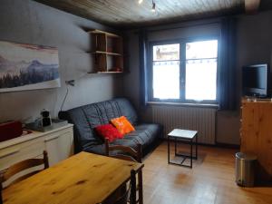 a living room with a couch and a table at Le Si-près Pied des pistes in Les Carroz d'Araches