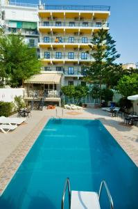 una piscina con un hotel en el fondo en Hotel Bakos, en Loutraki