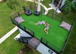 two people laying on a lawn in a house at Coconut Wells Phuket in Chalong