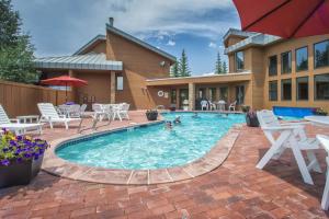 a swimming pool with tables and chairs and a house at Cool Ridge Town Home at Summerwood in Keystone