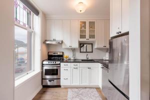 a white kitchen with white cabinets and a window at Jarvis #301 in Durango
