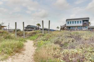 a house on a beach with a dirt road at Las Palmas Hacienda in Galveston