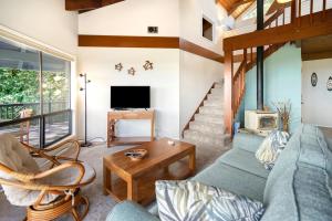 a living room with a blue couch and a table at Kalaheo View - TVNC 5018 in Kalaheo
