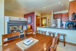 a kitchen and dining room with a table and a fireplace at The Cache in West Village in Copper Mountain