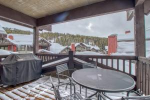 a patio with a table and chairs on a deck at The Cache in West Village in Copper Mountain