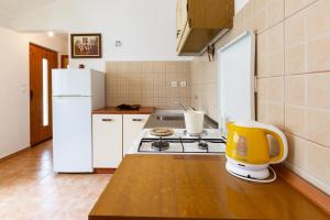 a kitchen with a stove and a white refrigerator at Sea view suite Mateo in Preko