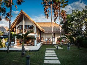 a house with palm trees in front of it at Villa Cantik in Lovina