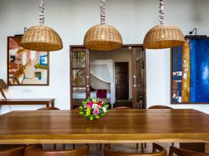 Villa Cantik في لوفينا: غرفة طعام مع طاولة خشبية مع إناء من الزهور