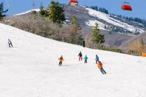 a group of people skiing down a snow covered slope at Park City Getaway in Park City