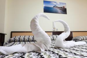 un par de toallas de cisne en una cama en Hostal la Campana, en La Línea de la Concepción