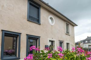 un edificio con finestre nere e fiori rosa di Ker Iliz a Bédée