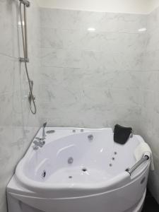 a white bath tub sitting next to a white toilet at Dimorra Boutique Rooms in Naples