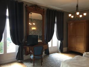 una camera da letto con specchio e scrivania con TV di Chateau de Vareilles a Sommant