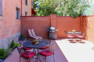 a patio with tables and chairs and a brick wall at Jarvis #301 in Durango