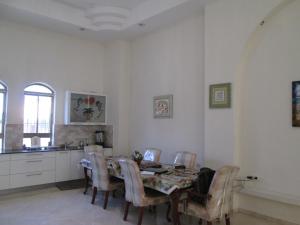 una cucina con un tavolo e sedie in una stanza di Beautiful 8 Bedrooms Villa in the Heart of Nahlaot a Gerusalemme Altre 13 foto