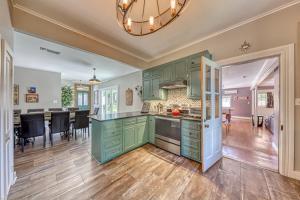 a kitchen with green cabinets and a dining room at Silver Lining 1898 in Fredericksburg