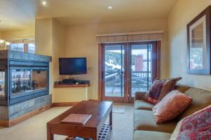 a living room with a couch and a fireplace at The Cache in West Village in Copper Mountain