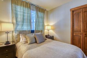 a bedroom with a bed with two lamps and a window at The Cache in West Village in Copper Mountain