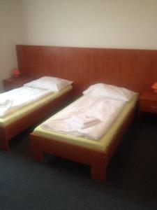 two twin beds in a room withermottermott at Hotel Růženy in Hustopeče