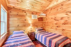 Duas camas num camarote com paredes de madeira em Family Oriented Cottage em Brant Lake