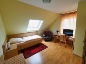 塞恩德的住宿－Gasthof Erfurth，一间卧室配有一张床和一张带电脑的书桌