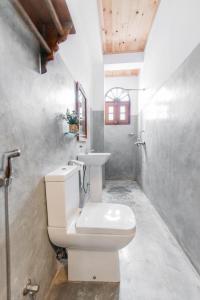 een badkamer met een wit toilet en een wastafel bij Fort Sapphire in Galle