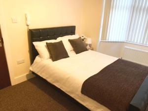 a bedroom with a large white bed with two pillows at Serviced Accommodations in Luton