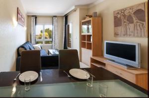 Una sala de estar con una mesa de comedor y un televisor. en Buganvilla, en Oliva