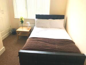duże łóżko w pokoju ze stołem w obiekcie Serviced Accommodations w Luton