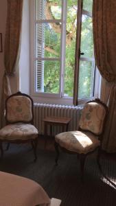 2 sillas y una mesa en una habitación con ventana en Manoir la Rumillette en Saint-Michel-sur-Loire