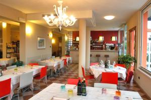 un restaurante con mesas y sillas y una lámpara de araña en Affittacamere Sale e Pepe, en Cavaion Veronese