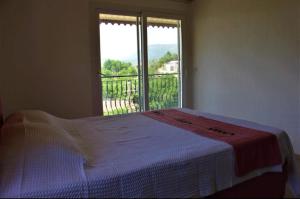 a bed in a room with a large window at Demir Apart-Otel in Kaş