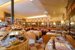 un ristorante con tavoli e sedie e cibo in esposizione di Hotel Rialto a Venezia