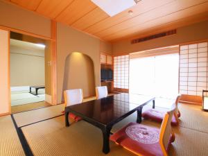 un soggiorno con tavolo da pranzo e sedie di Yorozuya a Yamanouchi