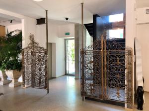 una puerta de metal ornamentada en una habitación con una planta en Ai Bastioni Boutique Hotel, en Treviso