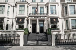 una puerta delantera de un edificio blanco con una escalera en Point A Kensington Olympia, en Londres