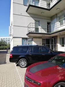 ワルシャワにあるSport Rooms II Chodakowska Warszawaの建物前に停まった青色のsuv