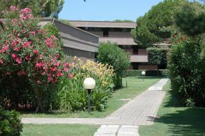 einen Garten mit rosa Blumen und einem Gebäude in der Unterkunft Residence Habitat in Marina di Bibbona