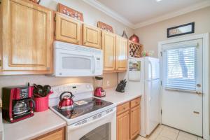 a kitchen with white appliances and wooden cabinets at Pristine Top Floor Condo With Access To Clubhouse & Pools in Phoenix