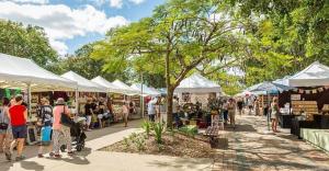a group of people walking around a market with tents at Eumundi Cottage in Town in Eumundi