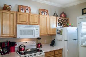 a kitchen with a white refrigerator and a microwave at Pristine Top Floor Condo With Access To Clubhouse & Pools in Phoenix