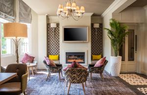 a living room with a fireplace and chairs and a tv at Point A Kensington Olympia in London
