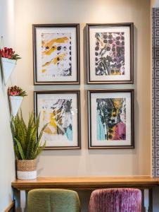 a group of framed pictures on a wall at Point A Kensington Olympia in London