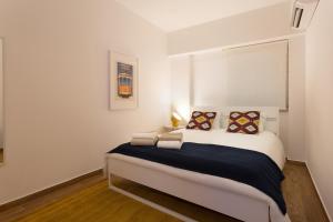 a bedroom with a large white bed with two pillows at Lisbon Zoo House II in Lisbon