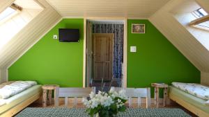 zielony pokój z dwoma łóżkami i telewizorem w obiekcie Wieża Na Górce w mieście Kunów