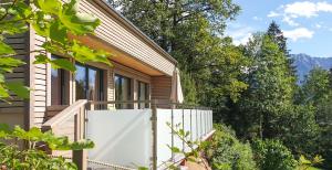 dom z białym płotem i drzewami w obiekcie Ferienbungalow Mountain View Wood w mieście Spital am Pyhrn