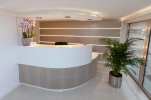 a lobby with a reception counter with a potted plant at Hotel Prinz Anton in Düsseldorf