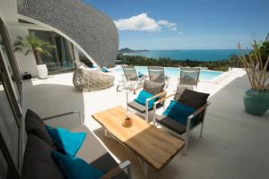 un patio con sillas, una mesa y una piscina en Villa Cocoon, en Chaweng Noi Beach