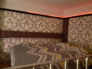 ein Schlafzimmer mit einem Bett und einer Tapetenwand in der Unterkunft Квартира студія подобово 3 in Lwiw