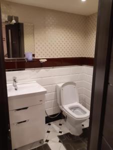ein Badezimmer mit einem weißen WC und einem Waschbecken in der Unterkunft Квартира студія подобово 3 in Lwiw